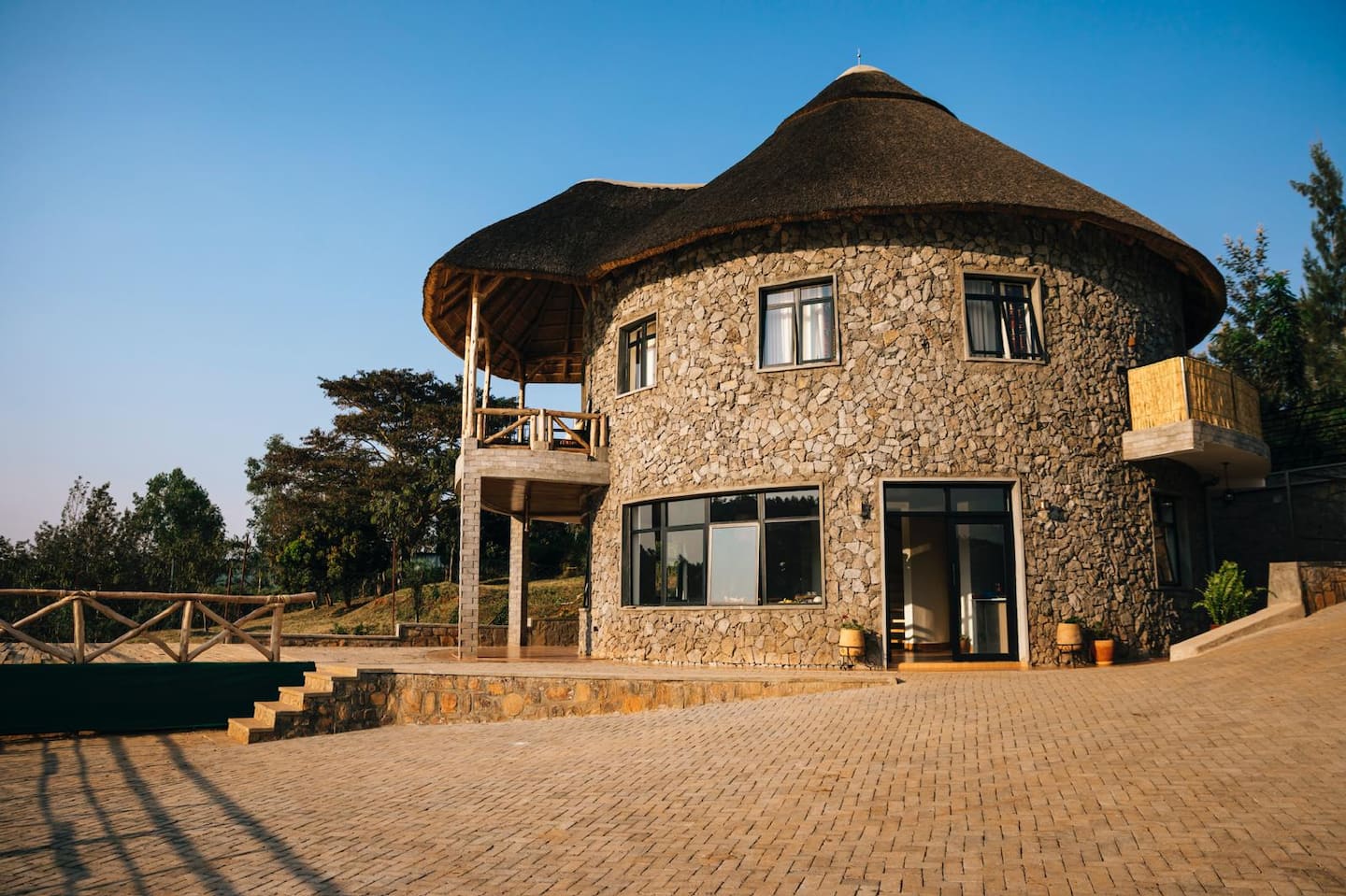 The stone round house with its thatched roof above Lake Muhazi