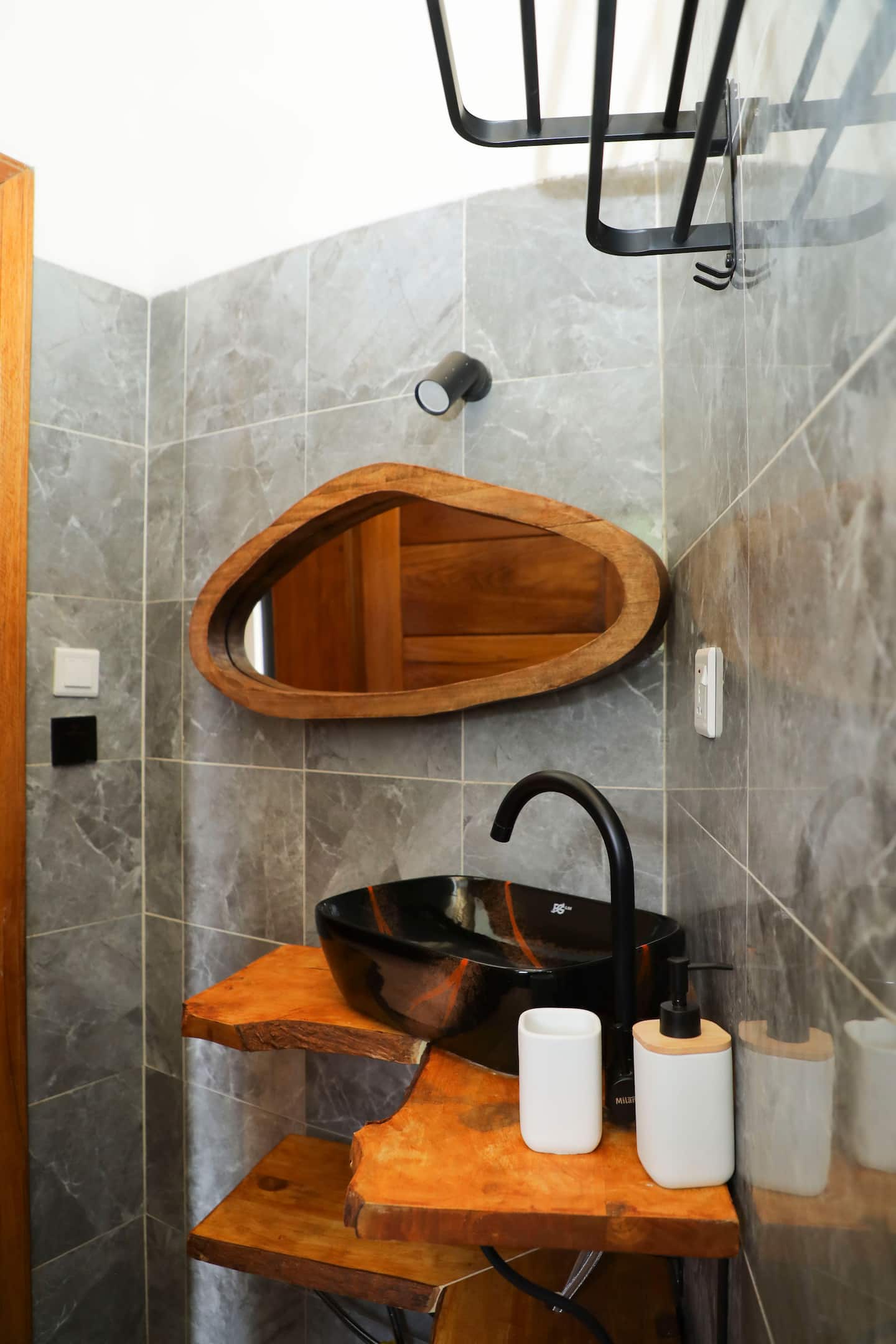 Bathroom with stone walls and carved wooden basin