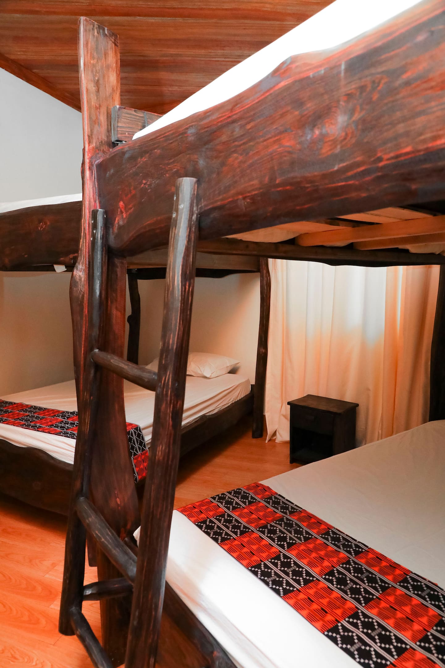Bedroom with raw-wood four poster bed and mosquito net